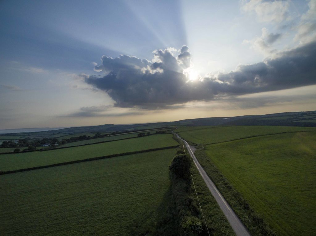 Drone photograph of a road leading off into the distance at Sunset.